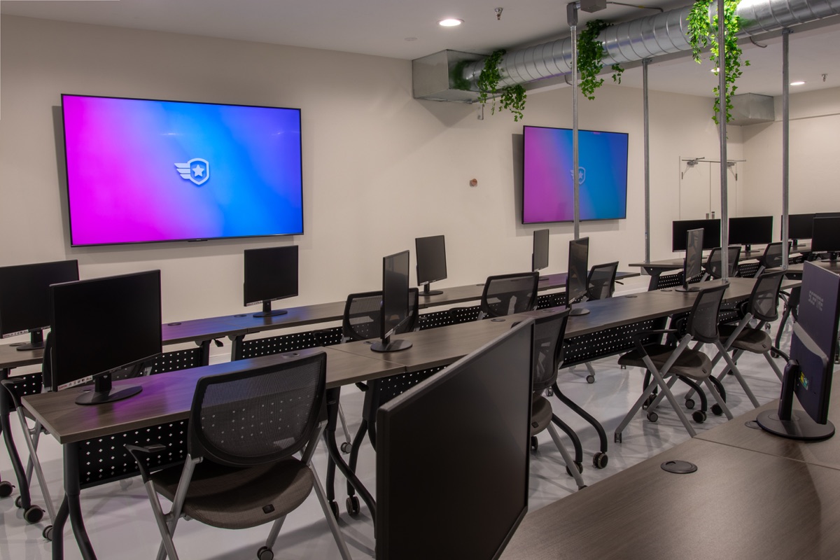 The dispatcher classroom: rows of student workstations facing two large wall displays