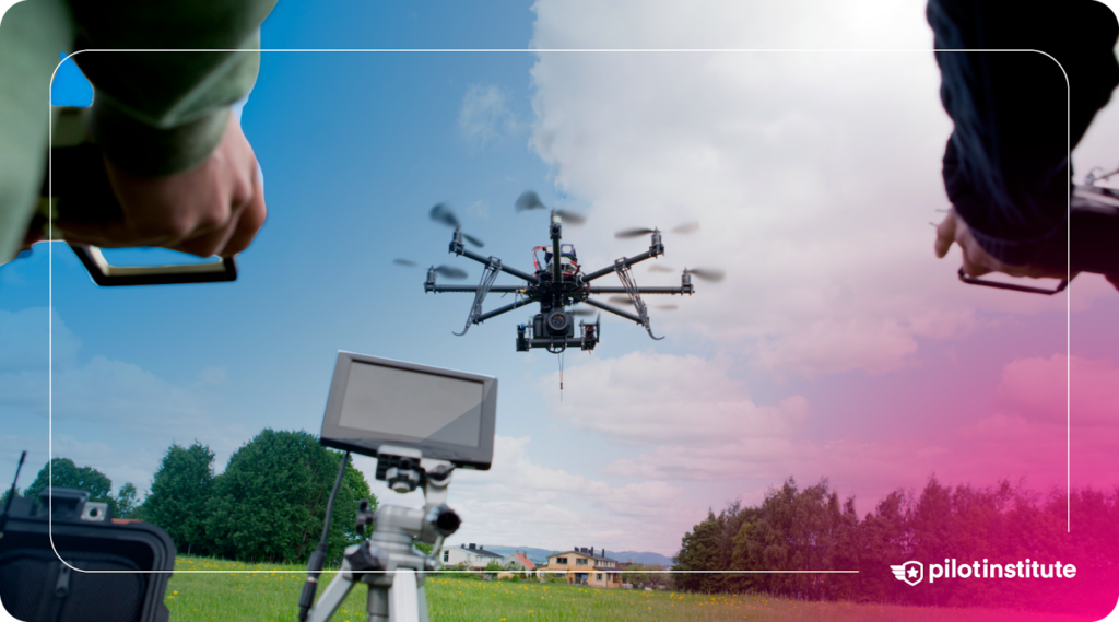 Close-up of drone pilots operating a large drone equipped with a camera, flying in an open field. Pilot Institute logo included.