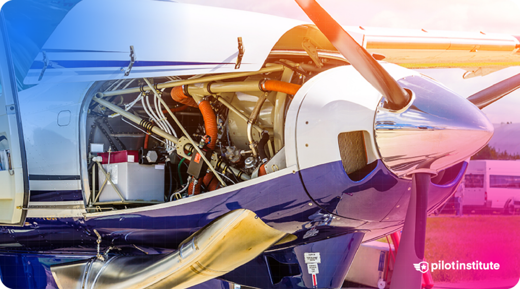 Close-up of a general aviation aircraft engine compartment with the cowl removed, showing internal components like hoses, battery, and propeller assembly.
