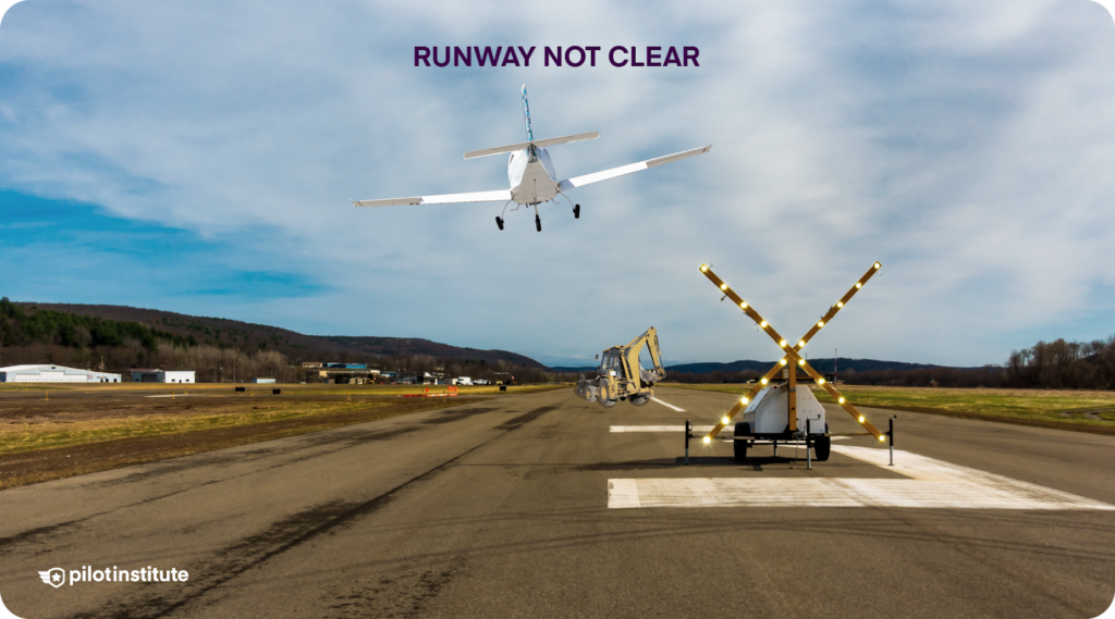 A small airplane performs a go-around over a runway closed for construction.