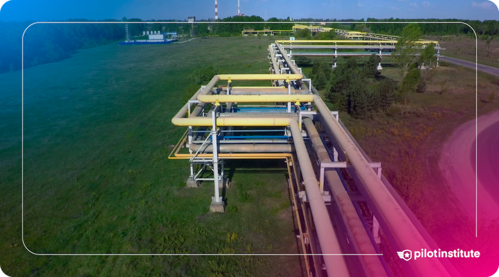 Aerial view of industrial pipelines running through a field. Pilot Institute logo included.